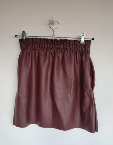Zara. Minifalda granate
imitación cuero con bolsillos